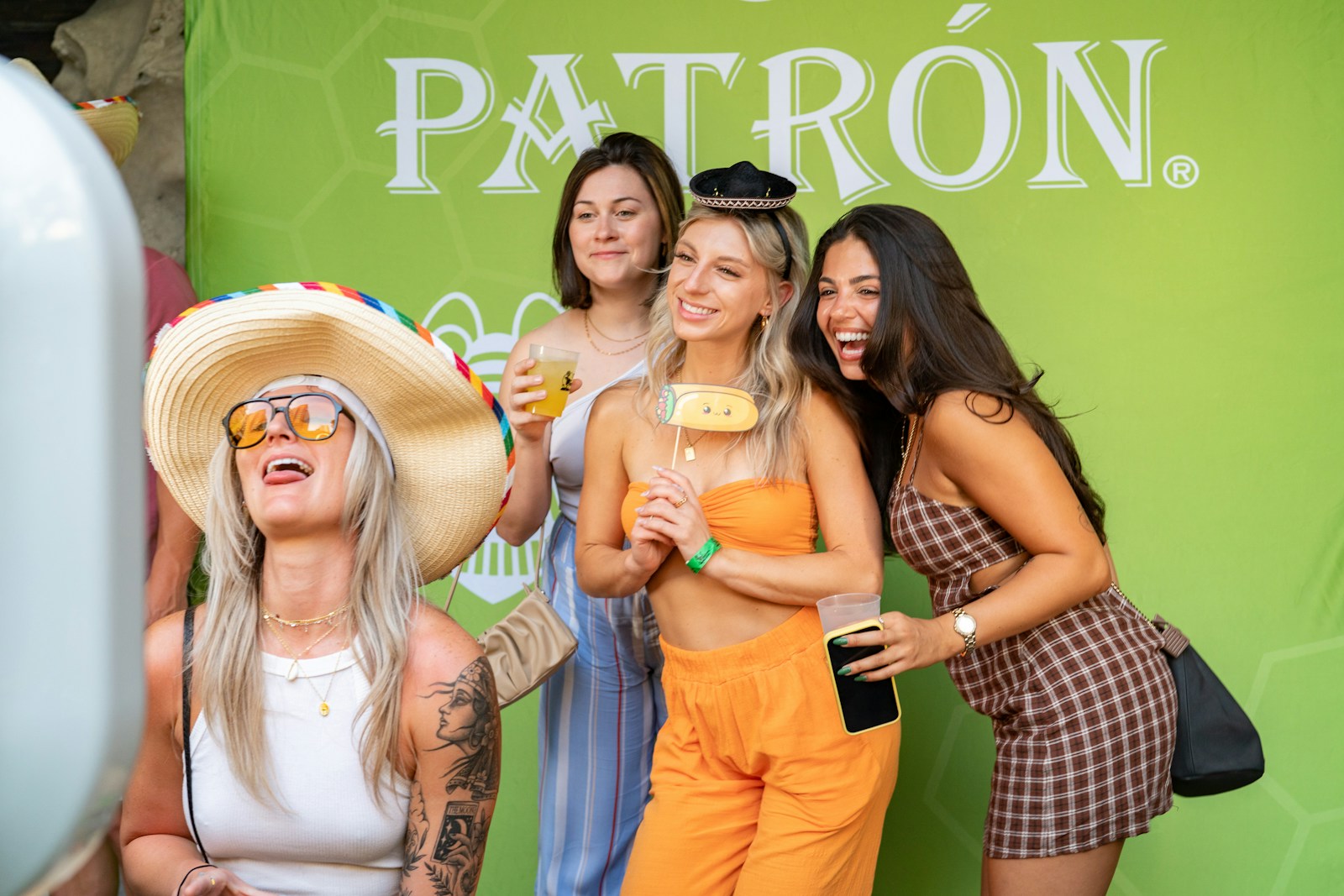 Friends pose happily in a photo booth with props